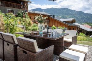 a patio with a table and chairs with mountains in the background at la maison des cerries in Hautecour