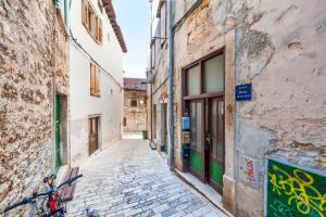 an alley in an old town with a bike parked on the side at Rovinj Romance Apartment in Rovinj