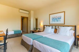 a hotel room with two beds and a desk at Hotel Hostalillo by Escampa Hotels in Tamariu