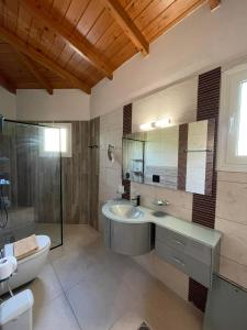 a bathroom with a sink and a toilet and a tub at Villa Adonis with private pool by Lefkadastay in Lefkada Town