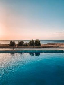 a swimming pool with the ocean in the background at Serenity Lodge in Sharm El Sheikh