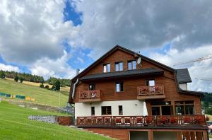 a large wooden house with a balcony at Alpejski Zieleniec in Duszniki Zdrój