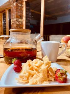 um prato de batatas fritas e um frasco de chá e morangos em Eco Village Lodge em Dzhetyoguz