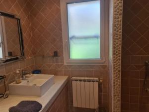 a bathroom with a sink and a window at Le Kallisté in Vaison-la-Romaine