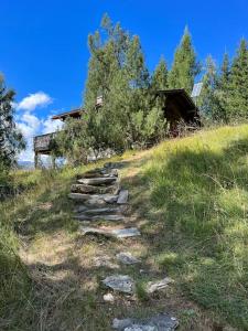 un sentiero in pietra che conduce a una casa su una collina di Beautiful Swiss chalet with breathtaking views and a sauna 