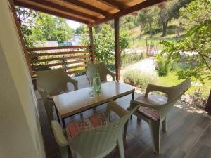 una mesa y sillas en un porche con vistas a un campo en Apartment Serenity, en Ohrid
