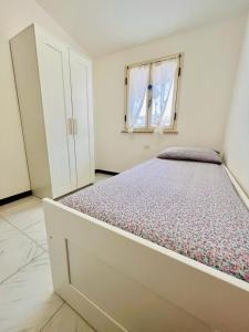 una camera con un letto in una stanza con una finestra di Daruma Apartment a Siniscola
