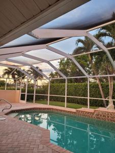 a swimming pool with an open roof with a swimming poolvisor at Marco Island Retreat- close to beach ! in Marco Island