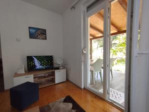 sala de estar con TV y puerta corredera de cristal en Apartment Serenity, en Ohrid