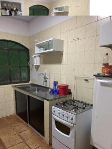 a small kitchen with a stove and a sink at Samambaia 01 in Brasilia