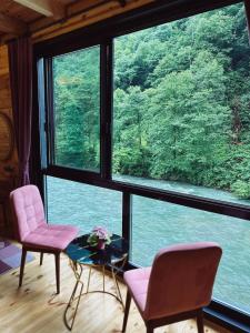 a room with two chairs and a table and a large window at Kiana Bungalov in Ardeşen