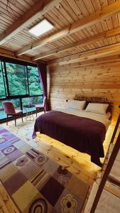 a bedroom with a bed in a log cabin at Kiana Bungalov in Ardeşen