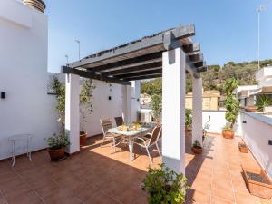 eine Terrasse mit einem Tisch und Stühlen auf dem Dach in der Unterkunft Faro's Malaga Citylights - Amazing Roof Terrace in Málaga
