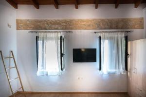 a room with two windows and a tv on the wall at Traditional stone house in Neokhórion