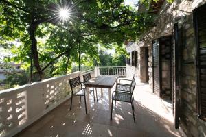 a patio with two chairs and a table on a balcony at Traditional stone house in Neokhórion