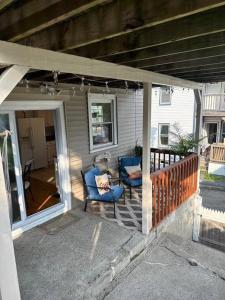 a porch of a house with two blue chairs at Farmhouse 2 bedrooms apartment in Lynn