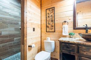 a bathroom with a toilet and a sink at Centrally Located Lux Cabin with Hot Tub, Fire Pit, EV Outlet in Broken Bow +16 photos