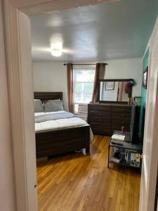 a bedroom with a bed and a dresser and a television at Farmhouse 2 bedrooms apartment in Lynn