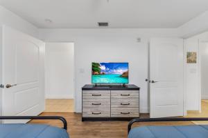 a bedroom with two beds and a tv on a dresser at 2BR condo minutes to Disney Springs in Orlando