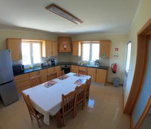 AlgarviaにあるCosta's Guest Houseのキッチン(テーブル、椅子、冷蔵庫付)