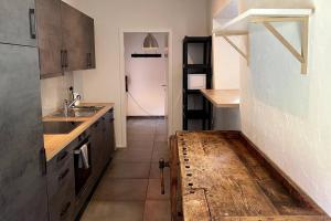 cocina con encimera, fregadero y puerta en triplex dans une ferme rénovée, en Gals