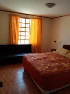 1 dormitorio con 1 cama y una ventana con cortinas de color naranja en Conectar con la naturaleza te hará más feliz, en Melipilla