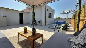 een patio met een tafel en stoelen en een parasol bij Holiday House Heraklion & Roof Garden in Heraklion
