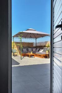 a patio with a table and an umbrella at Holiday House Heraklion & Roof Garden in Heraklio Town