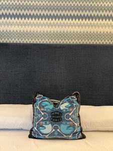 un cuscino blu seduto sopra un letto di My Secret Room Apartment vicino al lago a Verbania