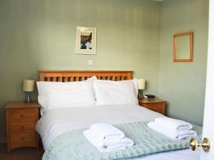 a bedroom with a bed with towels on it at Bell Island Cottage in Whitby