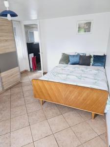 a bedroom with a wooden bed in a room at 3 rue Maurice Utrillo in Bourg-en-Bresse