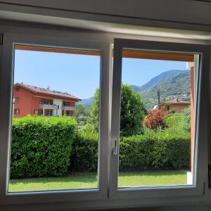 une fenêtre avec vue sur une maison dans l'établissement Sprio House, à Omegna