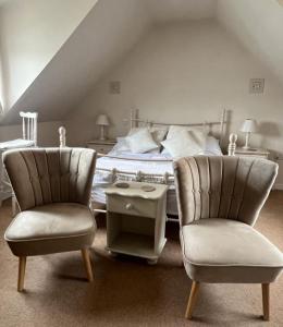 a bedroom with a bed with two chairs and a table at Laverick Steps in Whitby