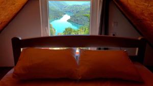 a bedroom with a window with a view of a river at Rural Resort Tron in Pluzine
