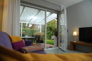 ein Wohnzimmer mit einer Glasschiebetür zu einer Terrasse in der Unterkunft Marhold Apartments in Drensteinfurt