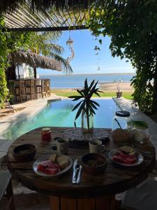 a table with food on it next to a pool at Coco-Knots Kite - Ilha do Guajiru in Itarema