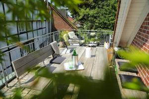 eine Holzterrasse mit einem Tisch und Stühlen auf dem Balkon in der Unterkunft Marhold Apartments in Drensteinfurt