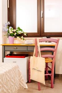a desk with a chair and a table with a bag at Domo Mediterranea Affittacamere-Guest House in SantʼAntìoco