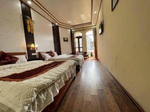 a hotel room with two beds and a hallway at Lotus Hotel in Sa Pa