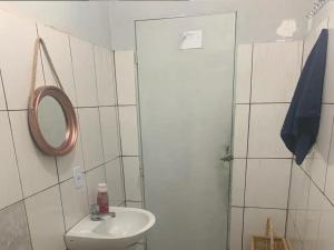 a white bathroom with a sink and a mirror at Samambaia 01 in Brasilia