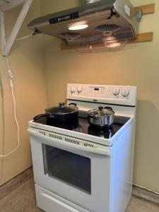 una cocina con fogones y 2 ollas. en Xinglin house, en Charlottetown