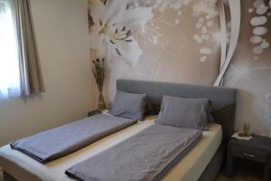 ein Bett mit zwei Kissen auf einem Zimmer in der Unterkunft Bungalow Serajnik in Sankt Kanzian am Klopeiner See