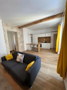 ein Wohnzimmer mit einem blauen Sofa und einer Küche in der Unterkunft Nimes centre ville appartement cosy 2 chambres in Nîmes