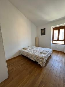 Schlafzimmer mit einem Bett und Holzboden in der Unterkunft Nimes centre ville appartement cosy 2 chambres in Nîmes