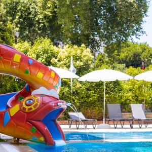 - un toboggan dans une piscine avec des chaises et des parasols dans l'établissement Cashmere Hotel, à Kusadası