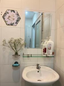 La salle de bains est pourvue d'un lavabo et d'un miroir. dans l'établissement JOY HOSTEL, à Hô-Chi-Minh-Ville