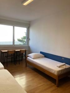 1 dormitorio con 1 cama y 1 mesa con sillas en Split Summer Budget Rooms, en Split