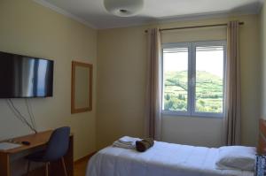 AlgarviaにあるCosta's Guest Houseのベッドと窓が備わるホテルルーム