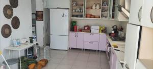 cocina con armarios blancos y nevera blanca en Bodrum / Relaxing, swimming, sunshine and sunbathing!, en Gürece