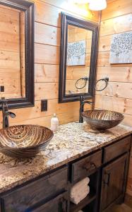 two sinks in a bathroom with two mirrors at Centrally Located Lux Cabin with Hot Tub, Fire Pit, EV Outlet in Broken Bow